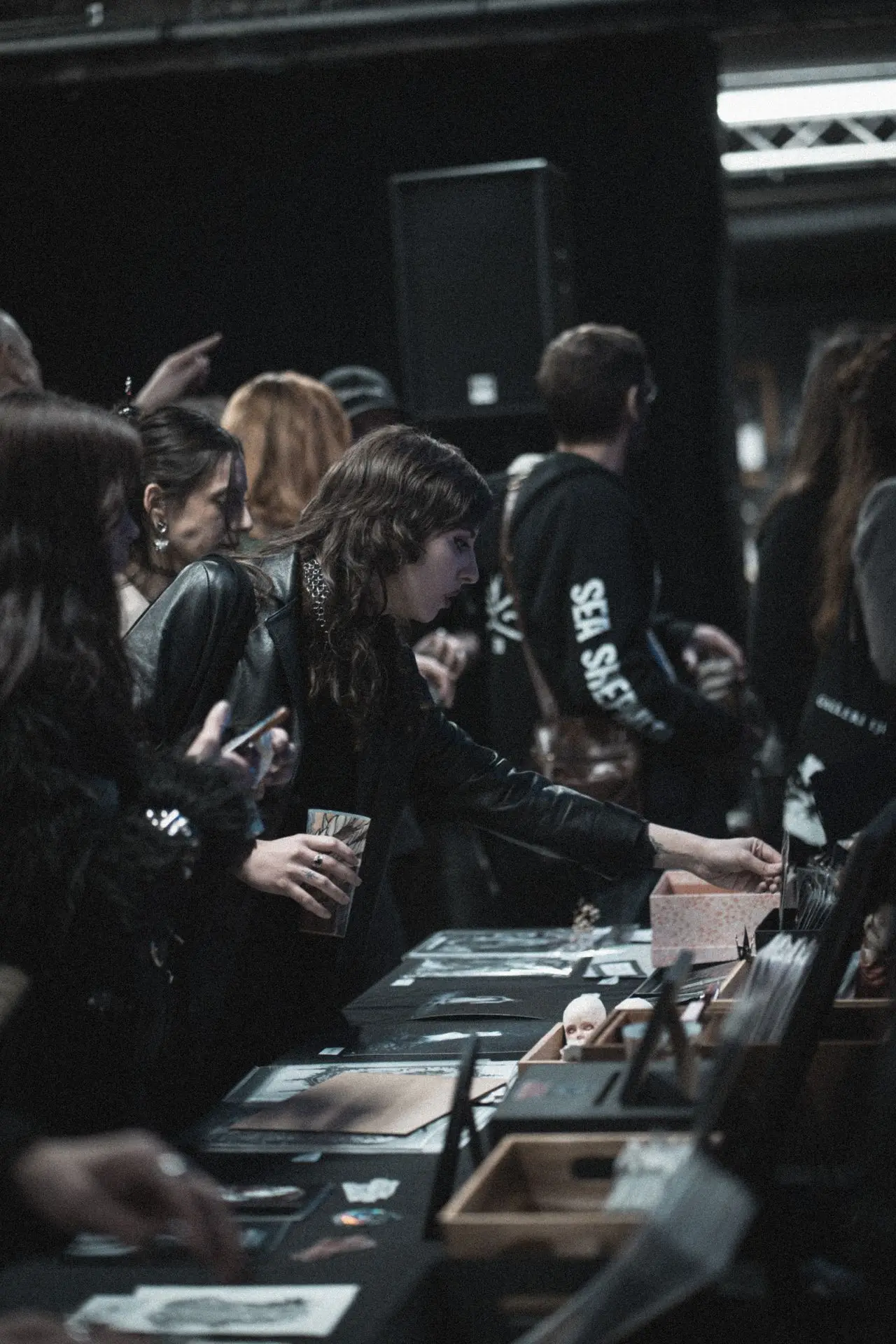 Visiteur-euses de l'exposition à la table de merchandising